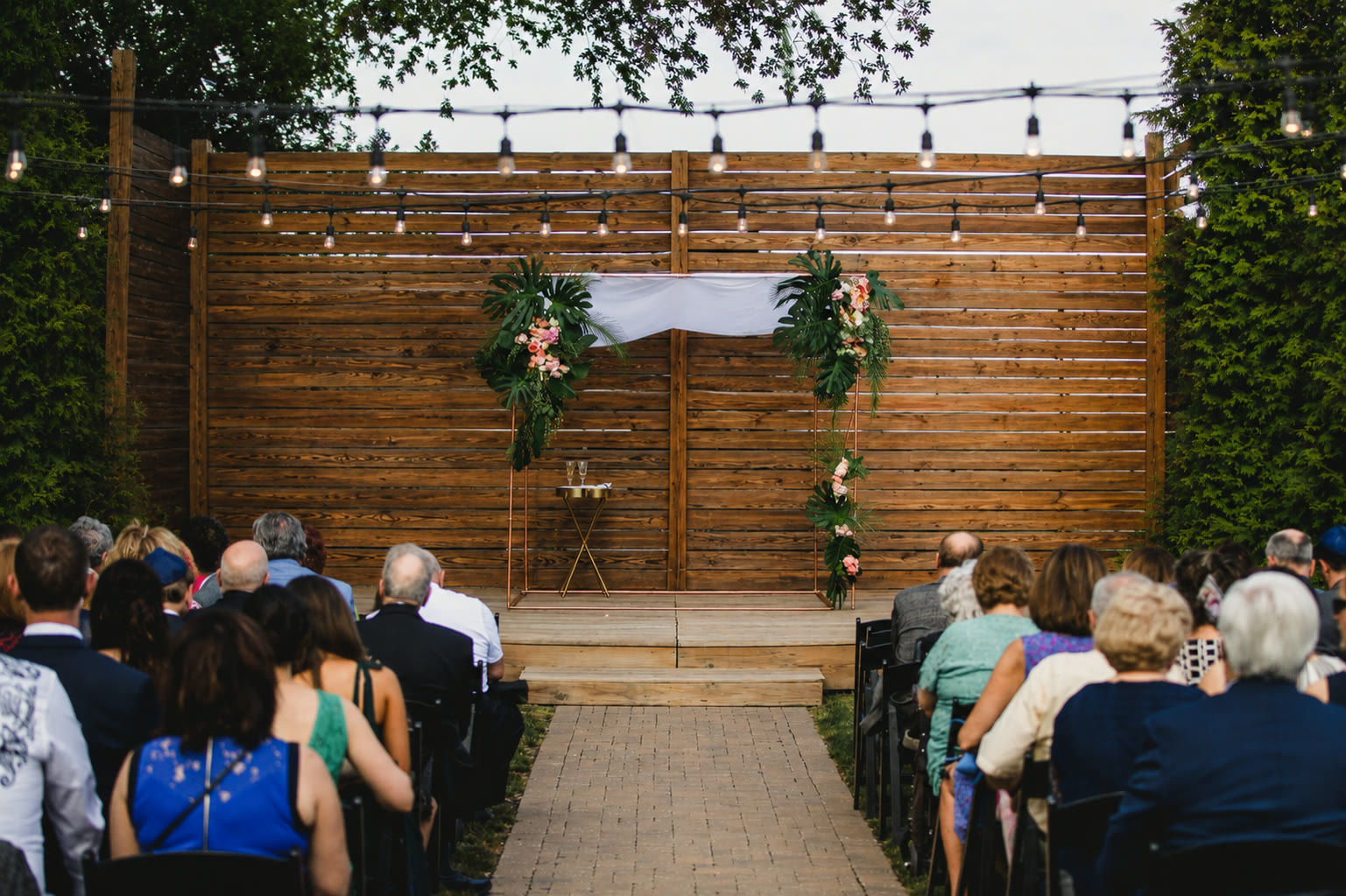 An outdoor evening ceremony under the copper chuppah
