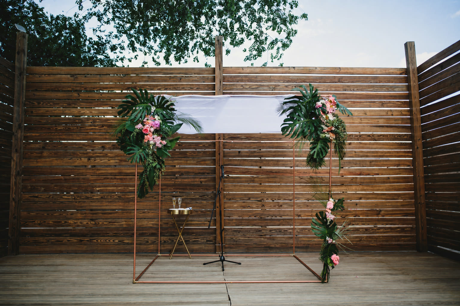 The copper chuppah outdoors on a raised stage
