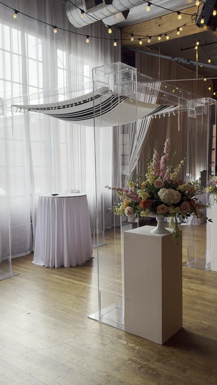 The acrylic chuppah dressed with a tallit canopy and florals